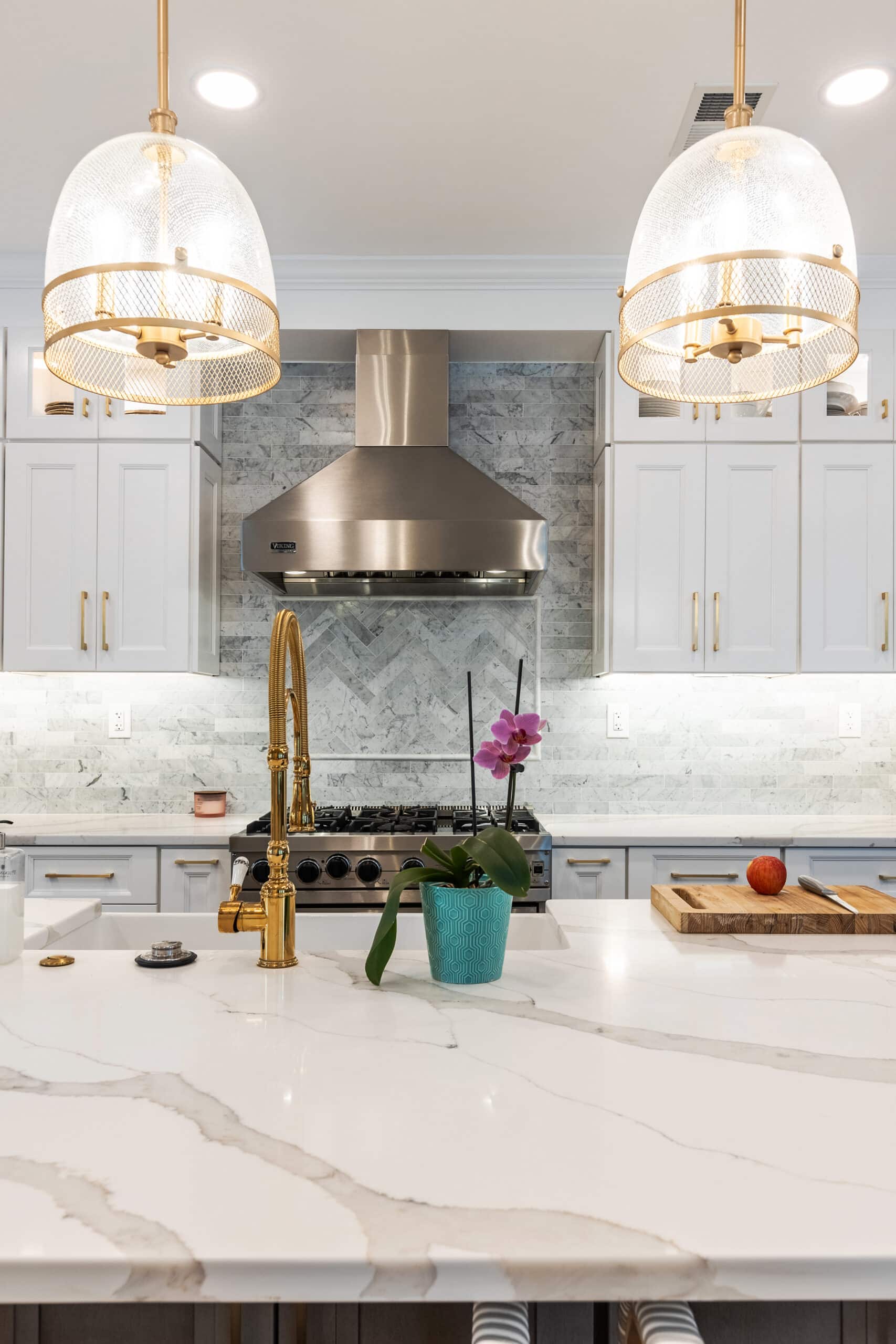 A kitchen with elegant marble counter tops and sleek white cabinet