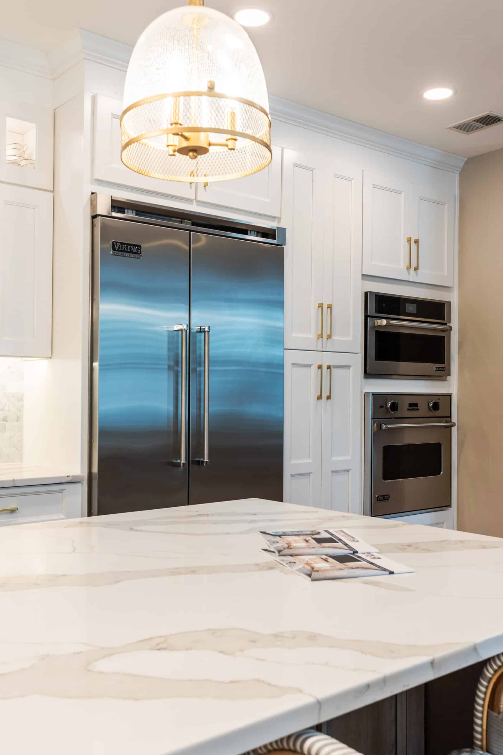 A kitchen with elegant marble countertops and sleek white cabinets