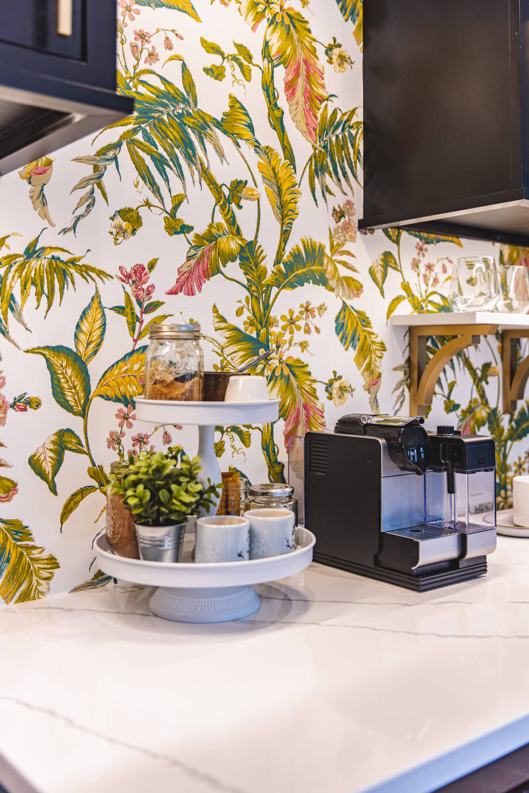 A kitchen with vibrant tropical wallpaper and a coffee maker