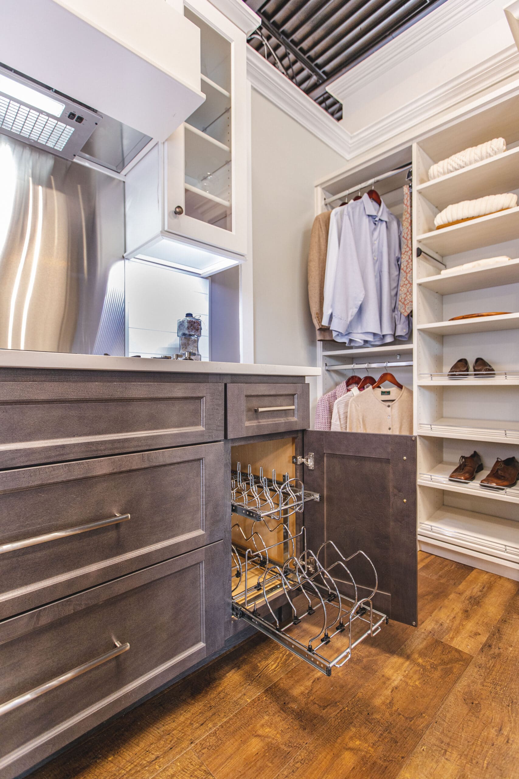 a walk in closet and brown cabinets with a large wooden floor