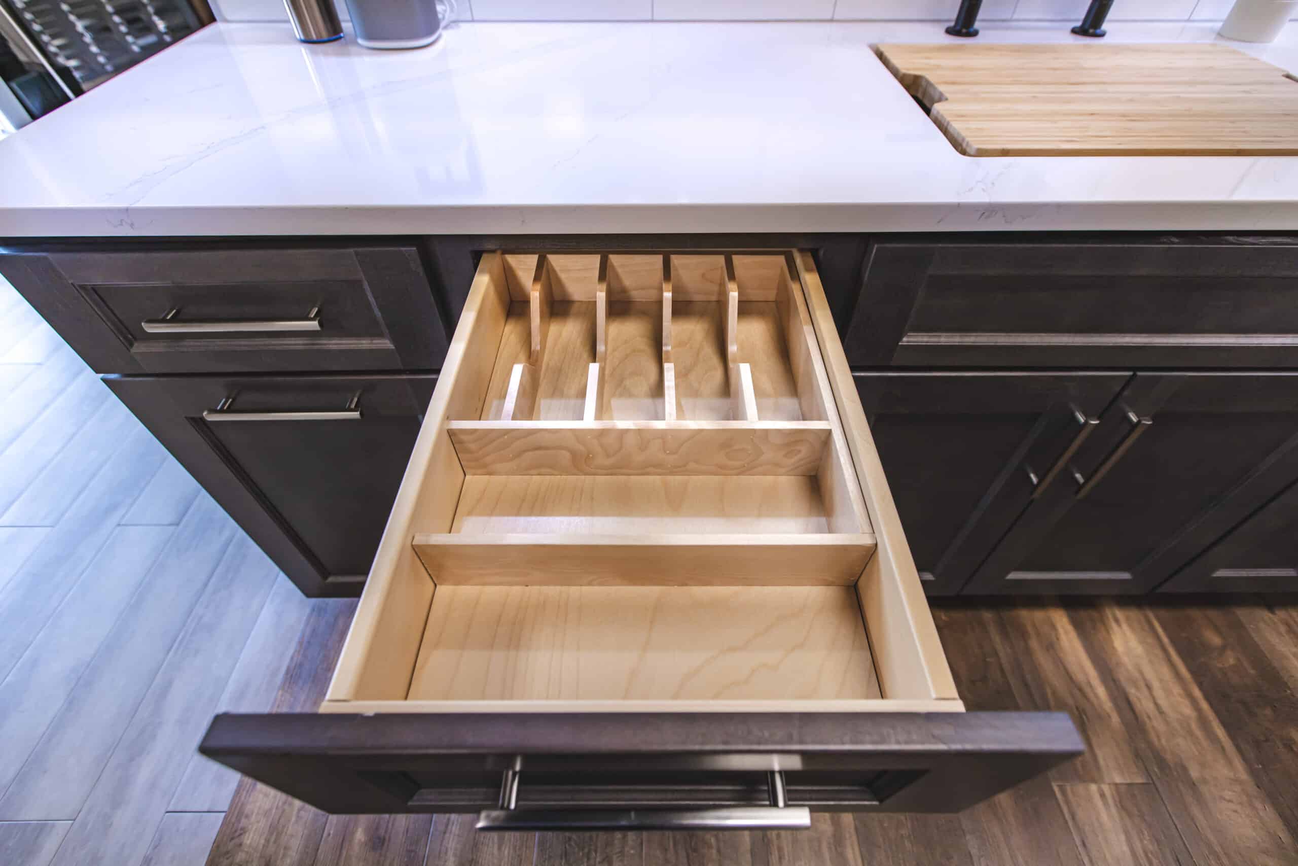 A kitchen with a wooden cutting board and a drawer