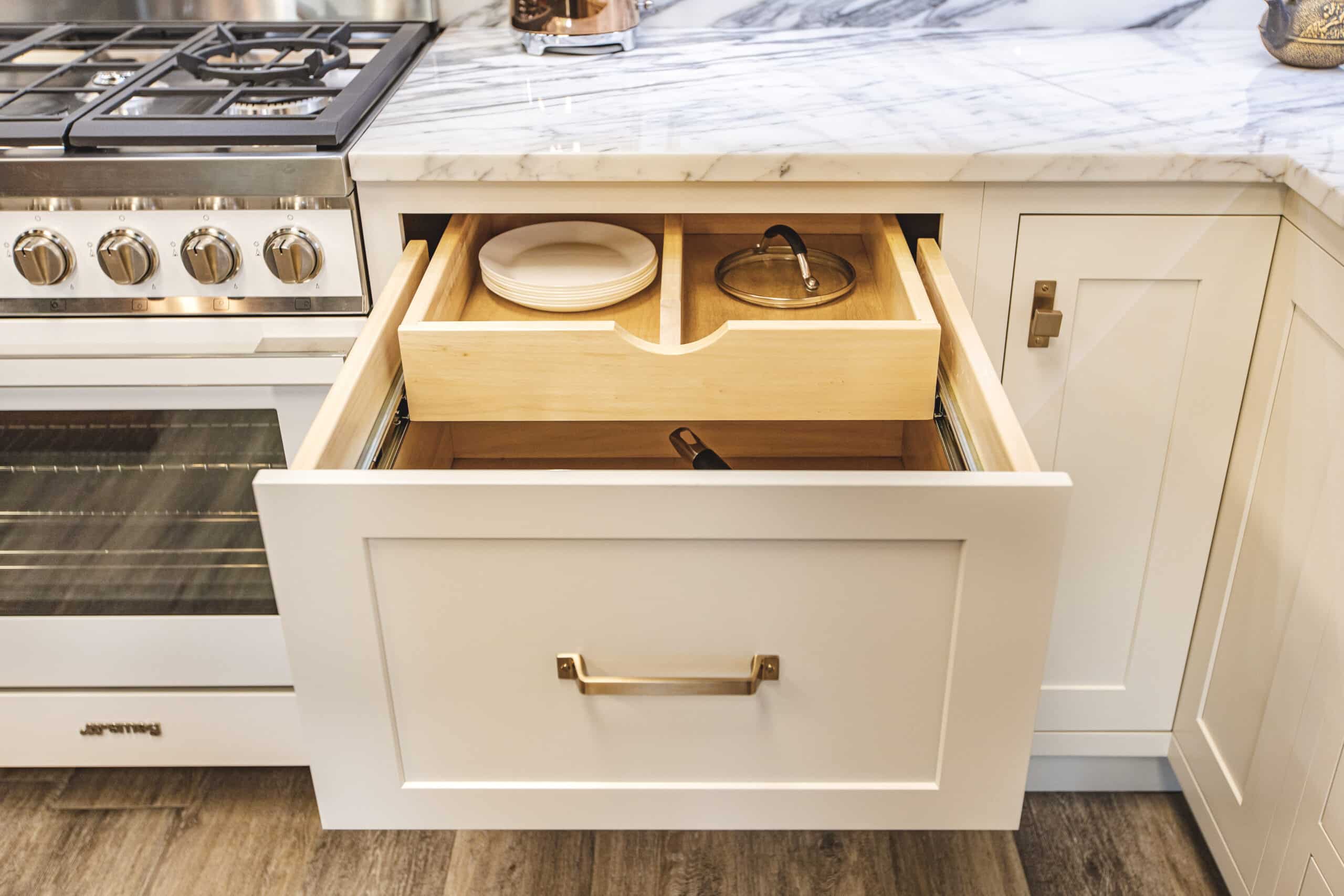 A white kitchen drawer and a marble countertops