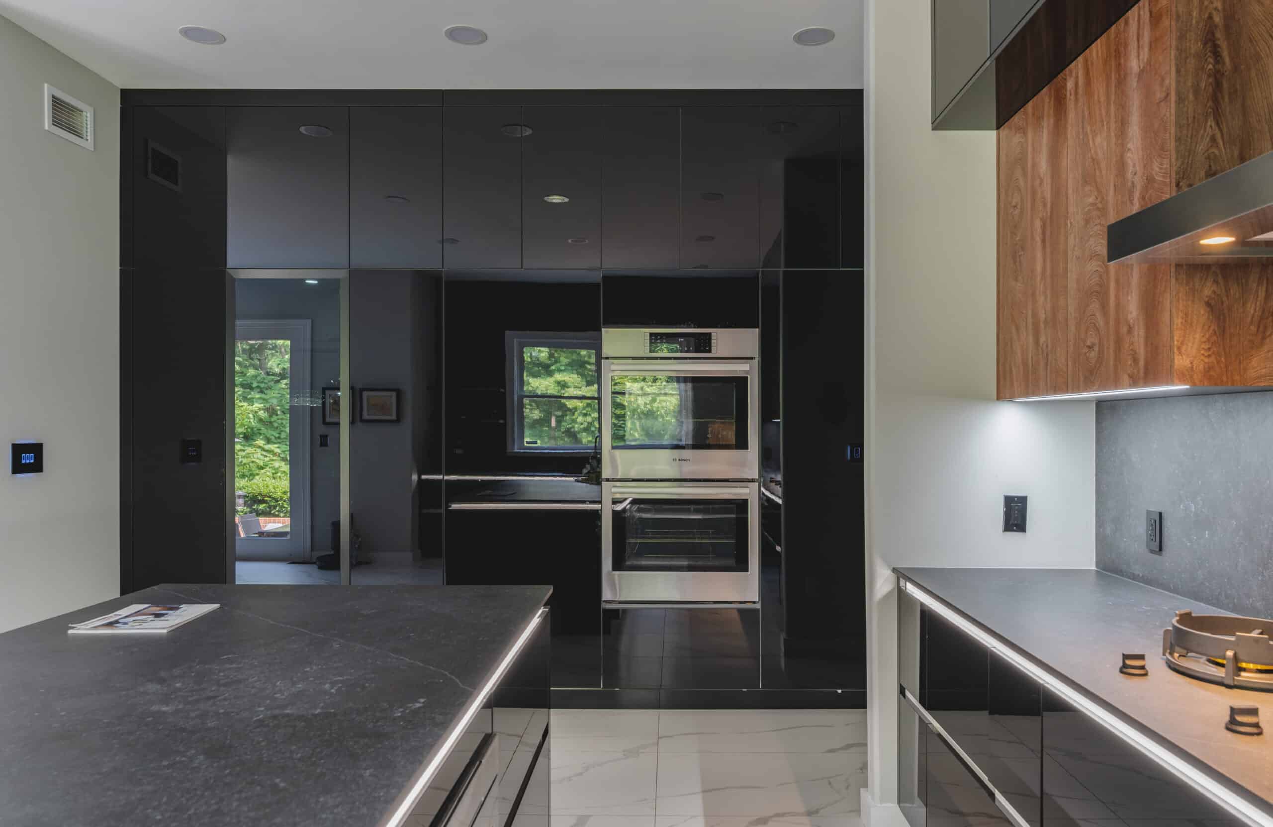 A contemporary kitchen featuring sleek black cabinets and countertops