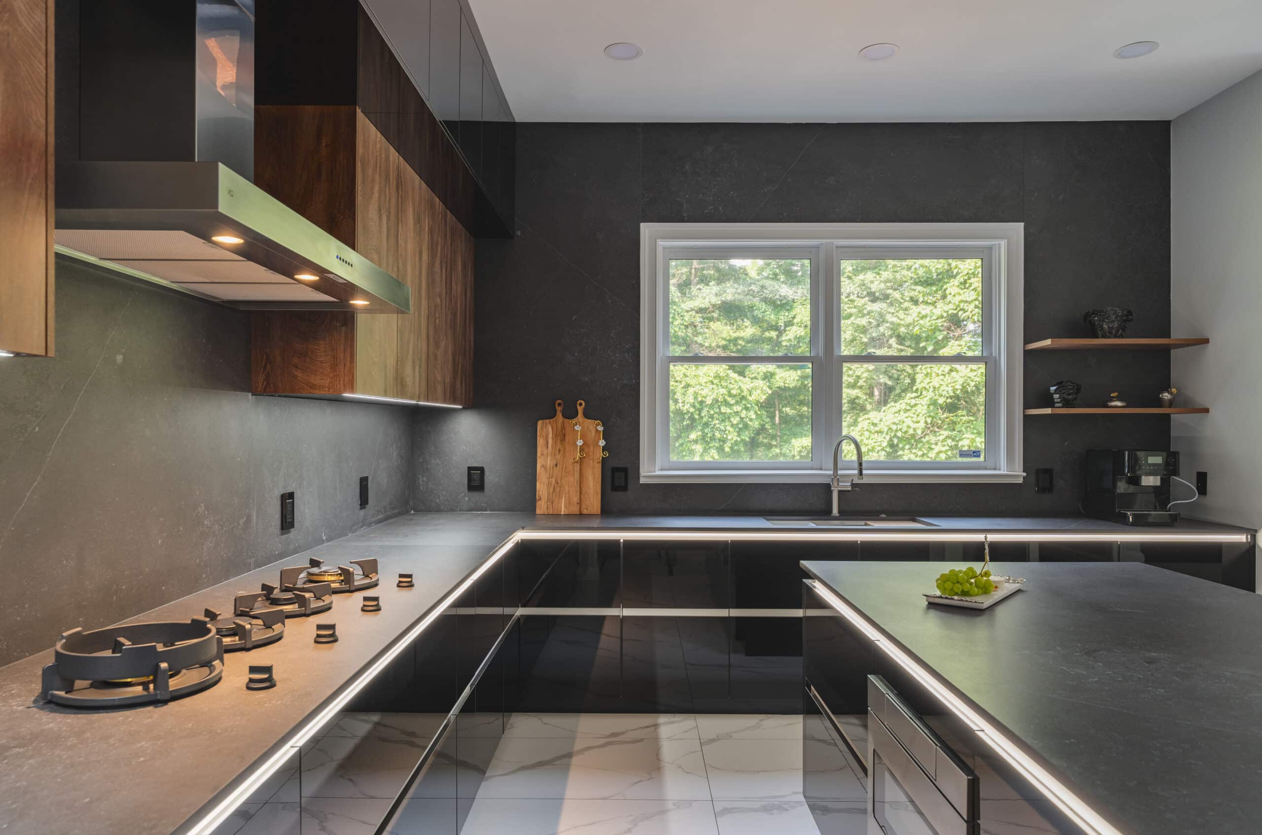 A contemporary kitchen featuring sleek black countertops and elegant wooden cabinets