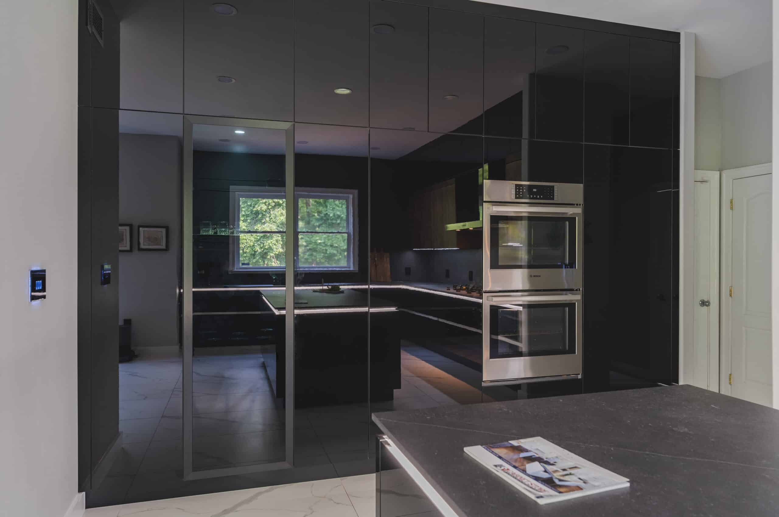 A contemporary kitchen featuring sleek black cabinets and black walls