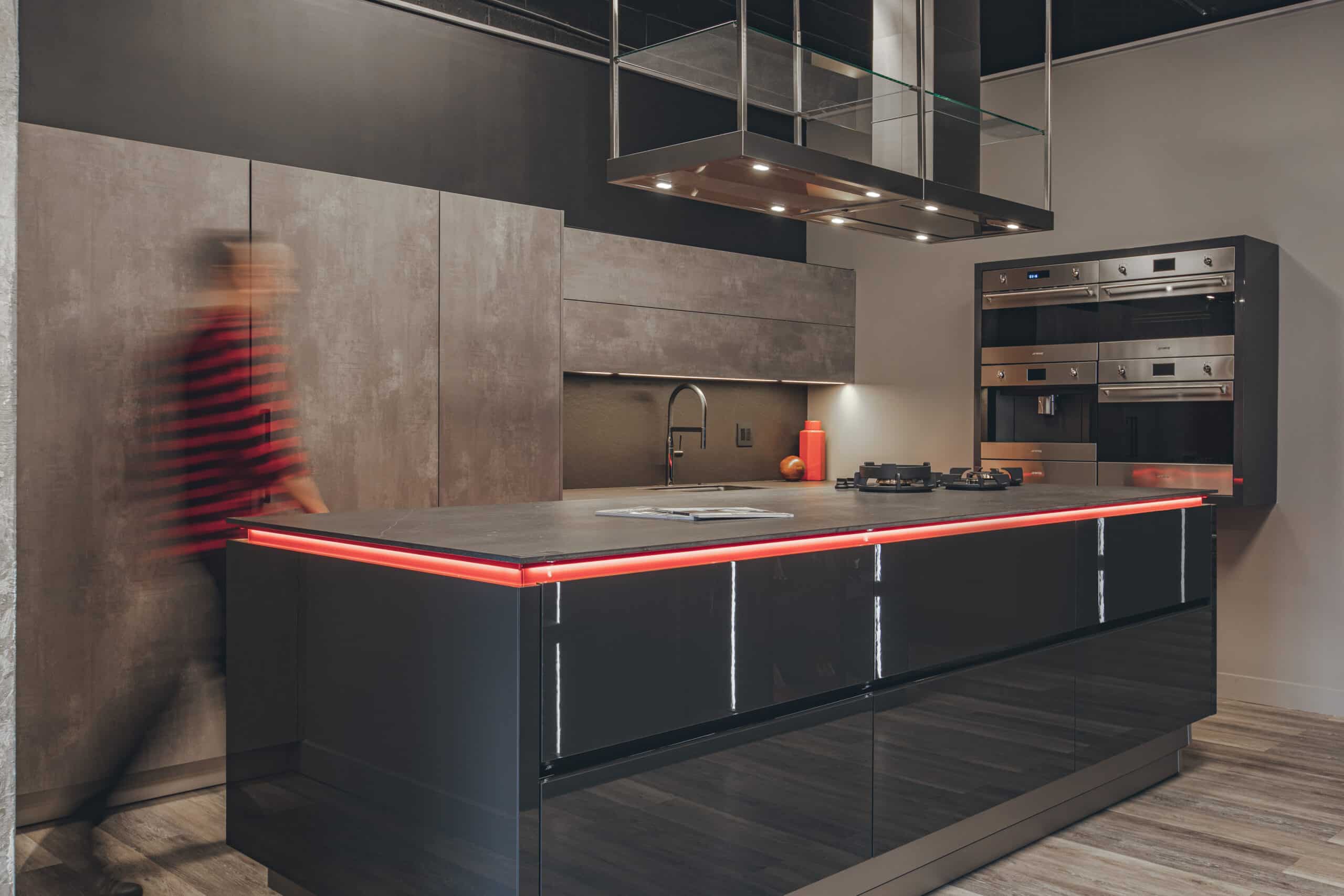 a kitchen with a black island and a red light
