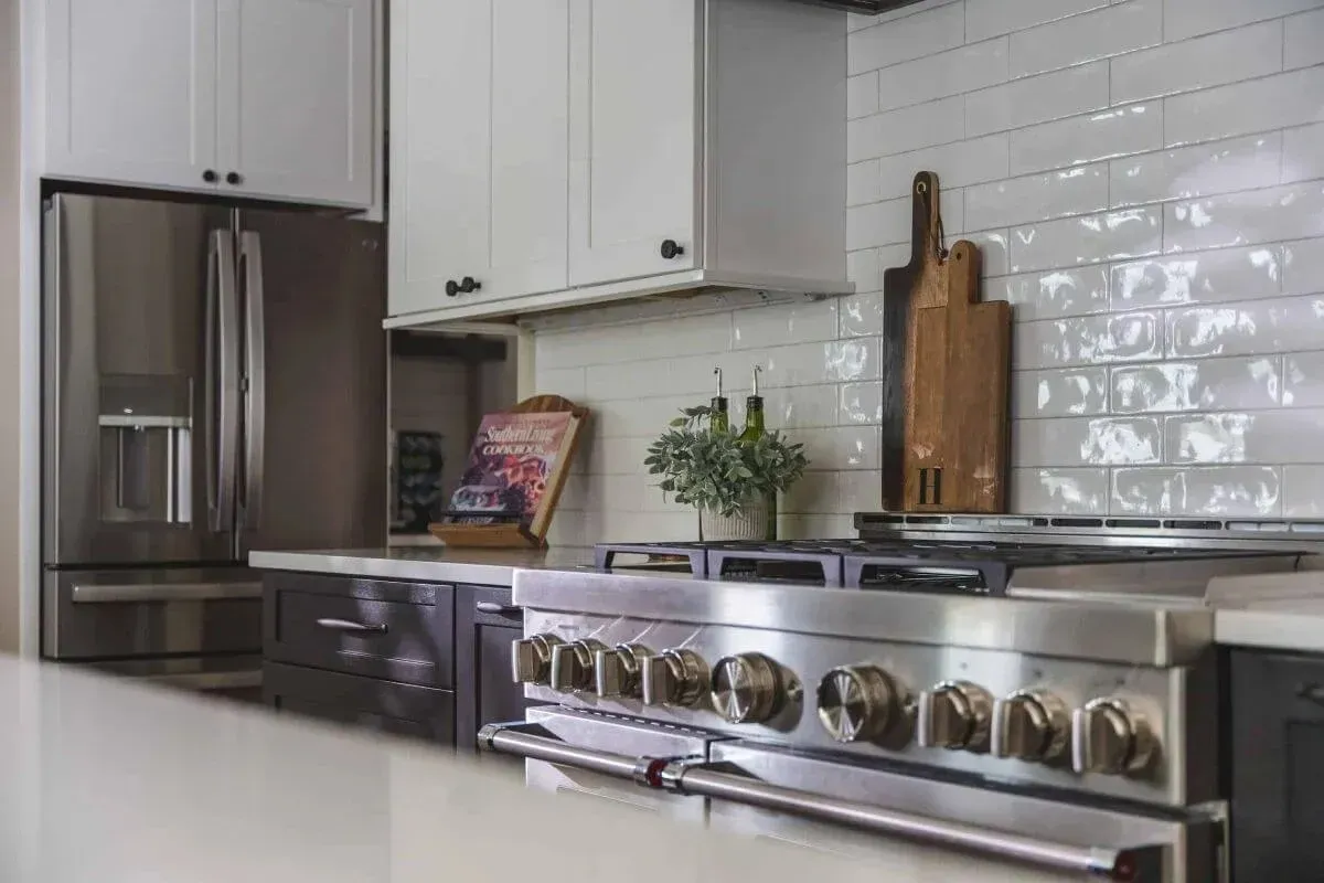 How Much Does a Kitchen Remodel Cost in 2026? 14 Park Creek Miyuki transitional kitchen with professional gas range, white subway tile, and custom cabinetry Small Kitchens (Under 70 Square Feet)