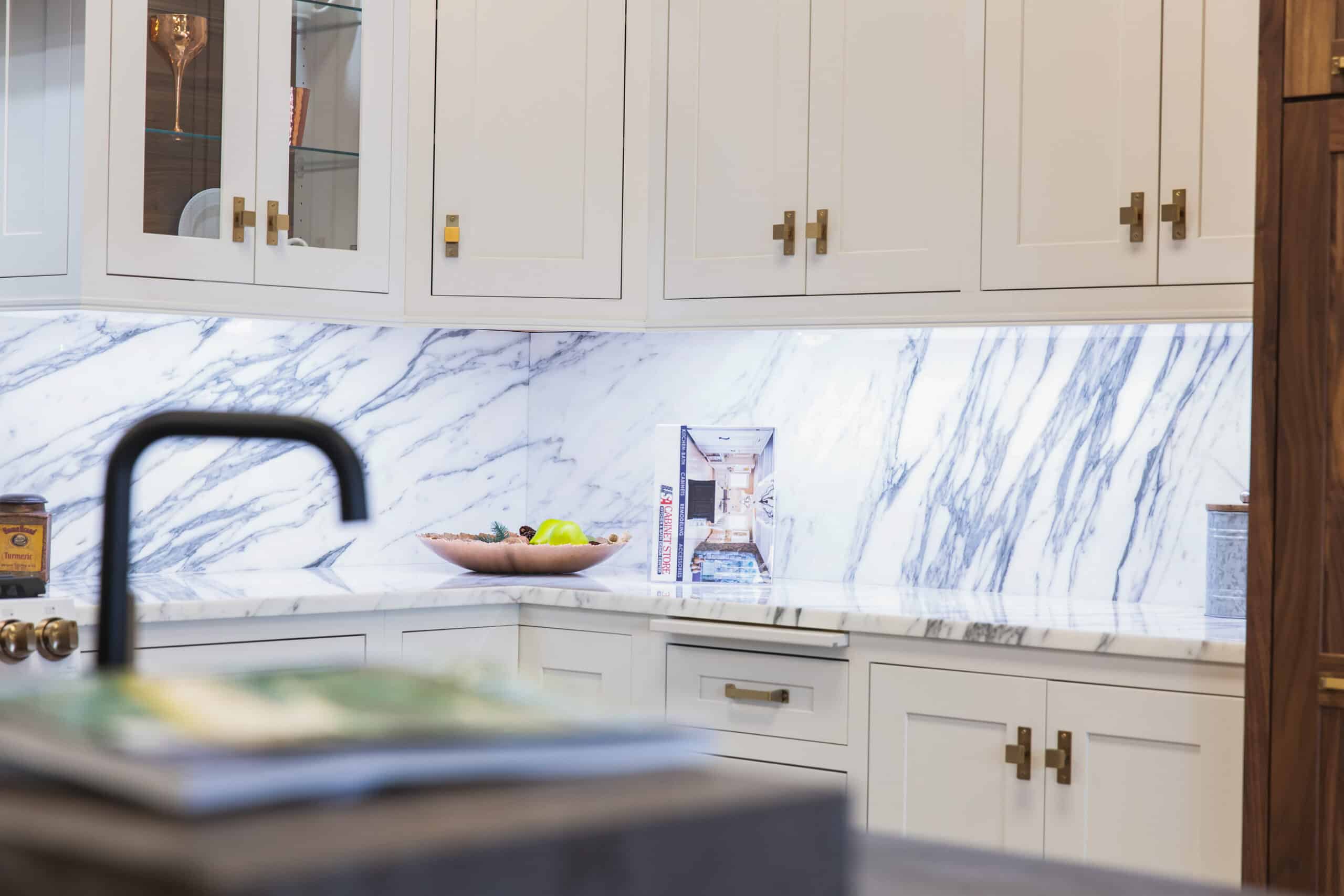 A modern kitchen with sleek marble countertops and pristine white cabinets