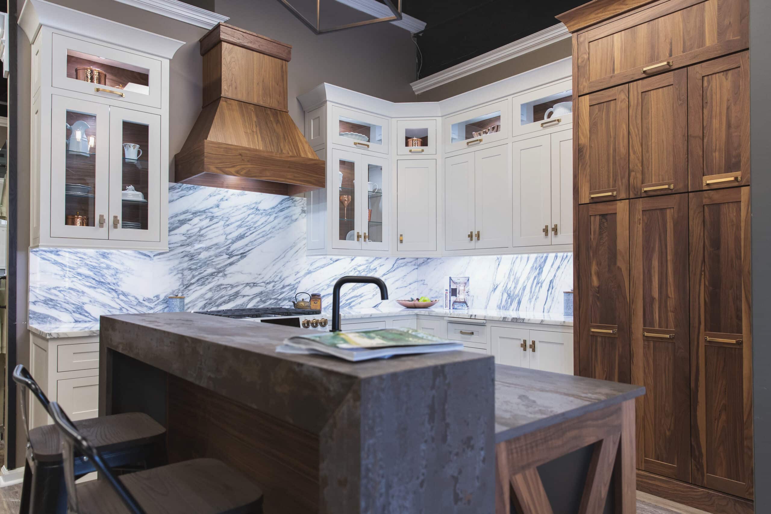 A kitchen with a sleek marble counter top and elegant wooden cabinets