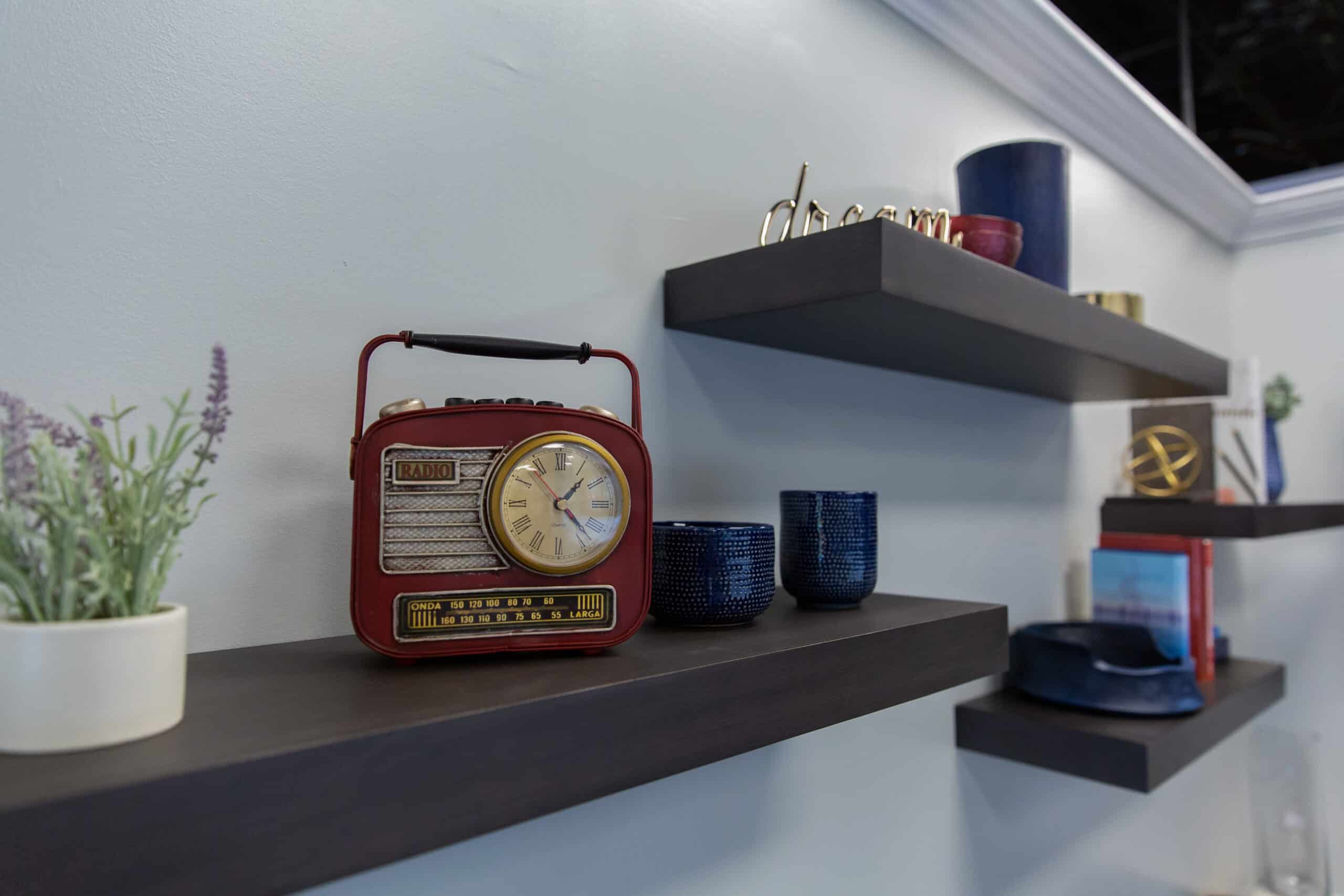 A shelf displaying a radio and a vase