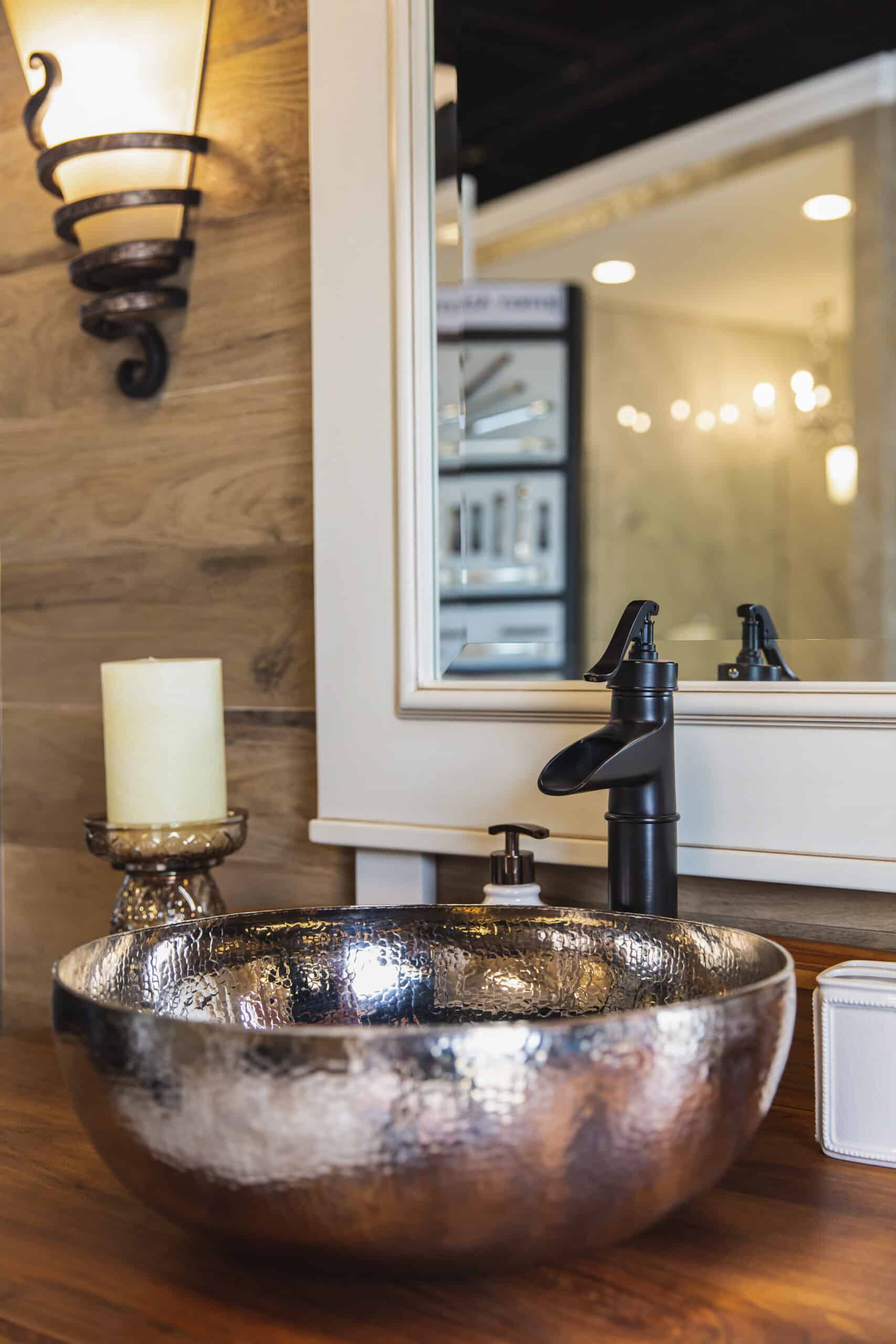 A bathroom sink with a mirror and wooden counter