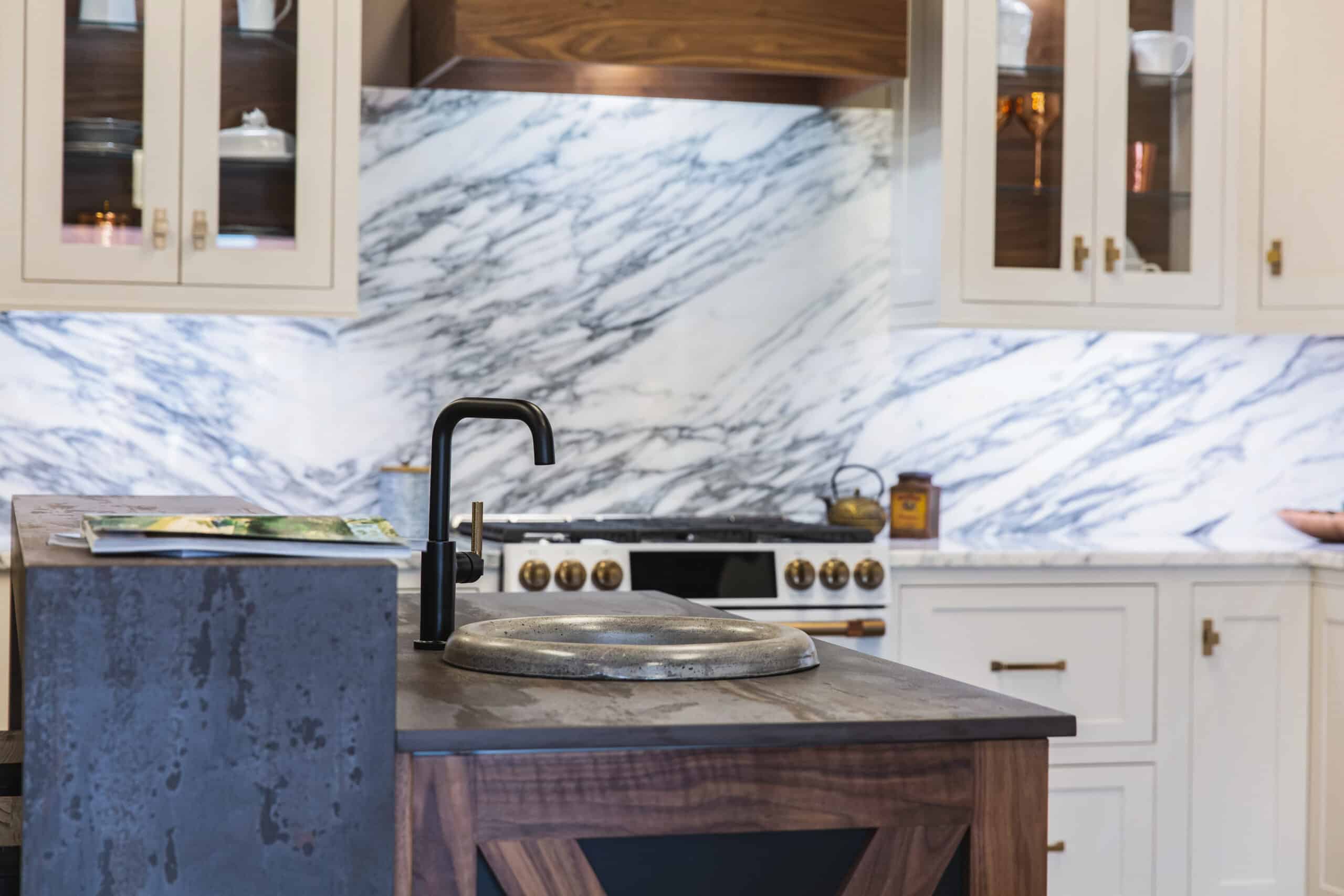 A modern kitchen with sleek marble countertops and a stylish black sink