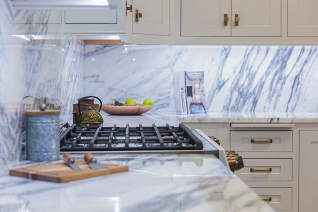 A modern kitchen with sleek marble countertops and a stainless steel stove