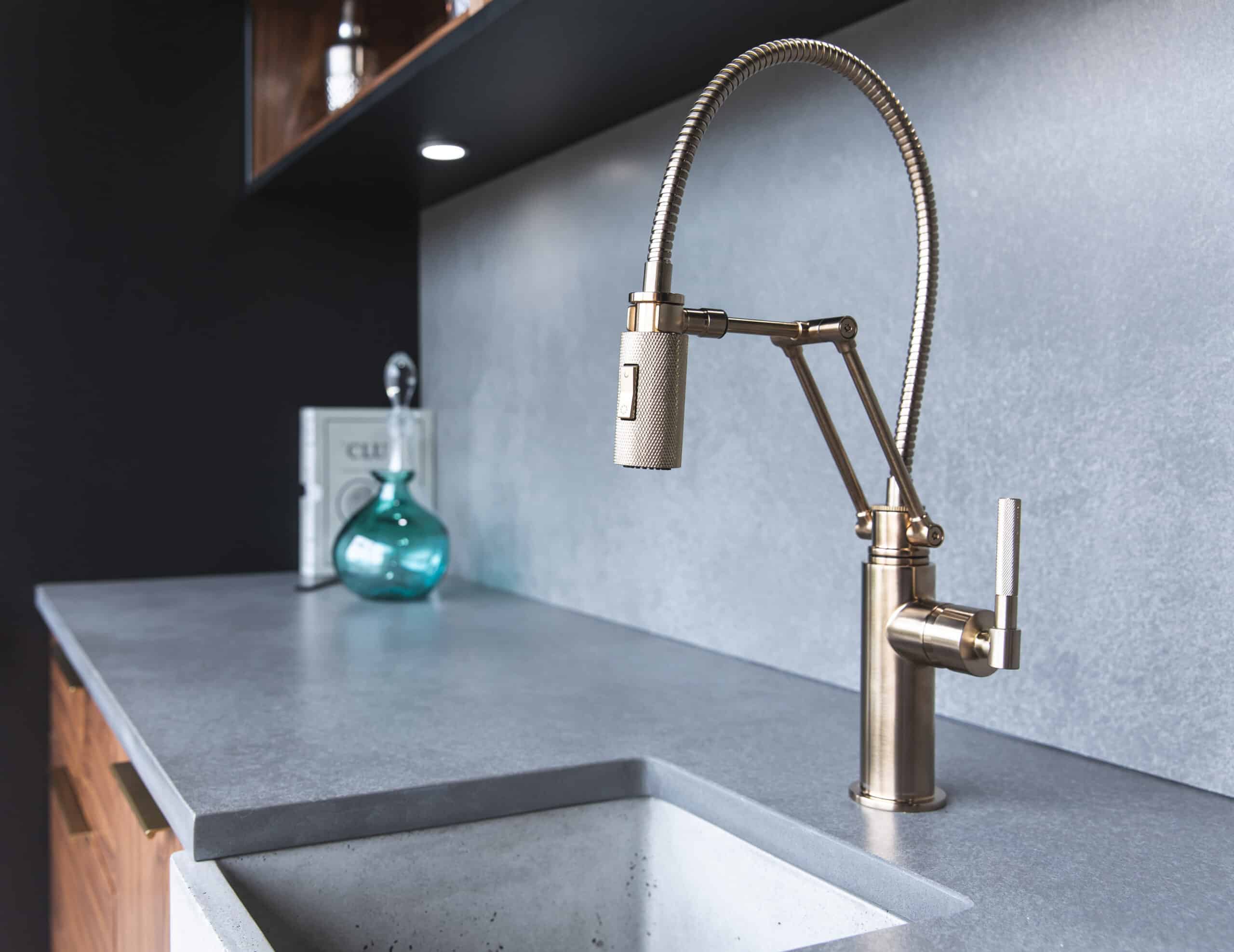 A modern kitchen sink with a brass faucet, adding elegance and functionality to any contemporary kitchen