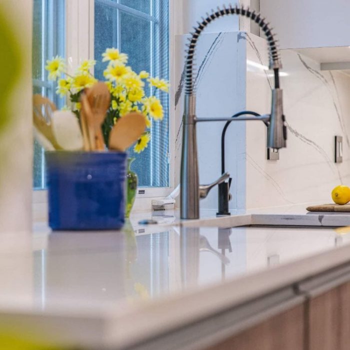 Fairfax kitchen sink detail featuring a commercial stainless steel faucet and a matte black filtered water dispenser.