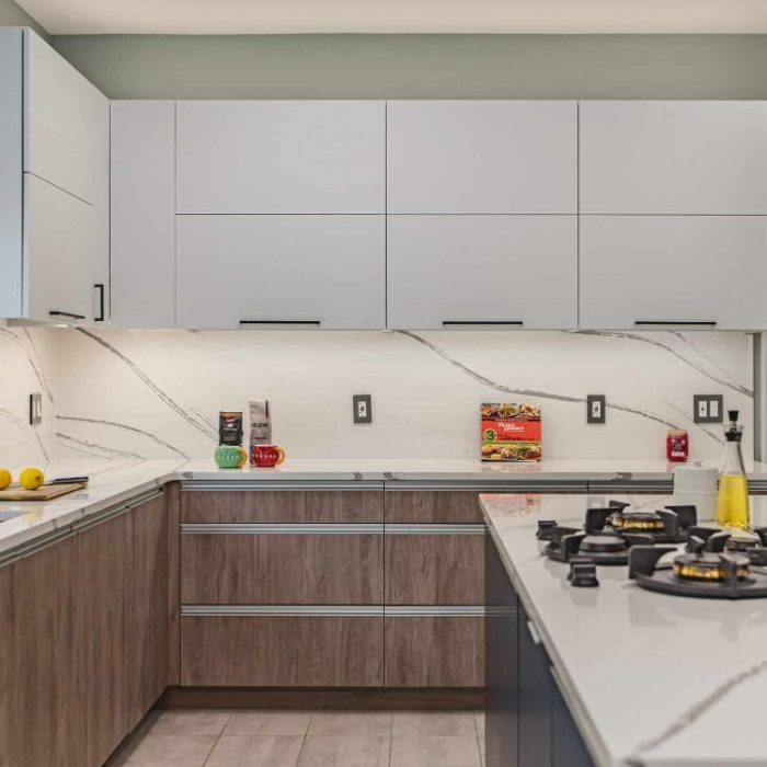 Fairfax kitchen remodel featuring trendy tri-tone cabinets: navy island, wood grain base units, and white uppers with full-height quartz backsplash.