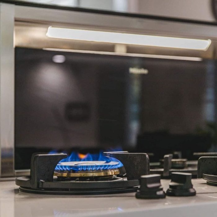 Fairfax kitchen island featuring a Miele retractable downdraft vent behind a gas cooktop with blue flame.