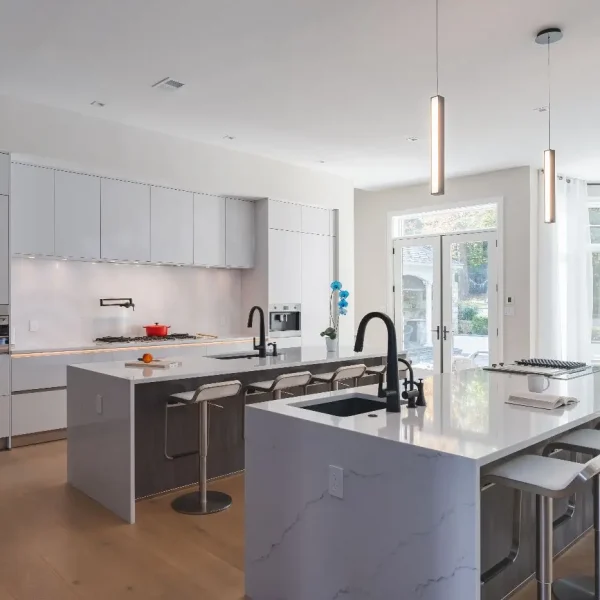Modern white kitchen with double islands, waterfall quartz countertops, and minimalist lighting in McLean VA.