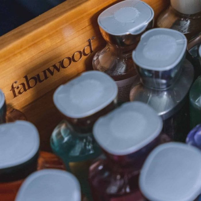 Close-up of a solid wood Fabuwood drawer with engraved logo, featuring dovetail construction and organized bathroom storage.