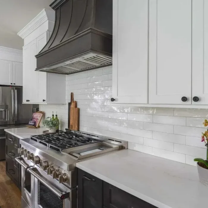 Park Creek Miyuki transitional kitchen with white shaker cabinets, dark range hood, and professional gas range