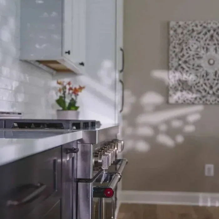 Park Creek Miyuki kitchen detail with professional gas range, dark wood cabinets, and white quartz countertops