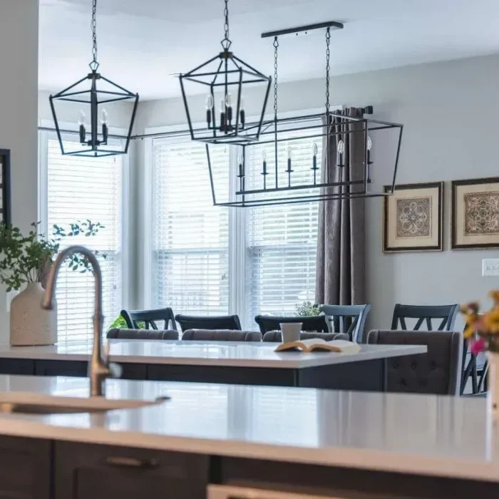 Park Creek Miyuki open-concept kitchen with bronze geometric pendant lights and sunlit dining area