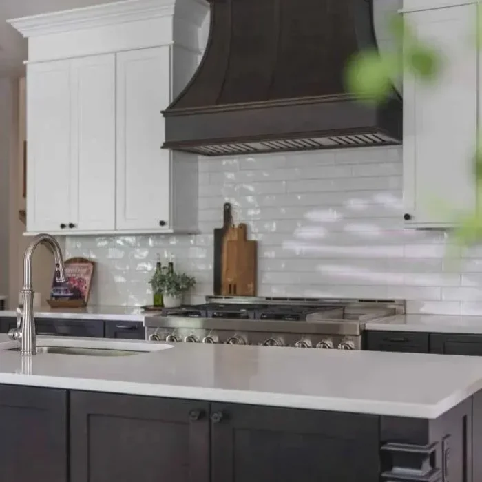 Park Creek Miyuki kitchen close-up with glazed white subway tile backsplash and dark wood range hood