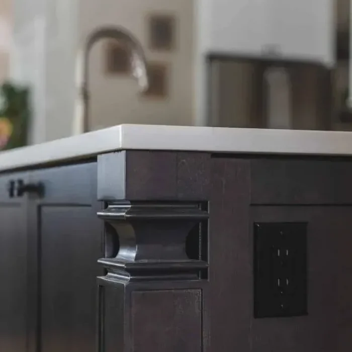 Park Creek Miyuki custom kitchen island detail with dark wood molding and integrated power outlet